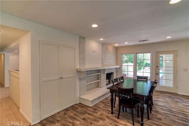 dining area featuring a fireplace, visible vents, wood finished floors, and recessed lighting