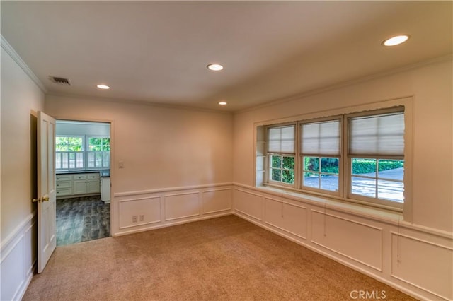 spare room with recessed lighting, carpet, visible vents, and ornamental molding