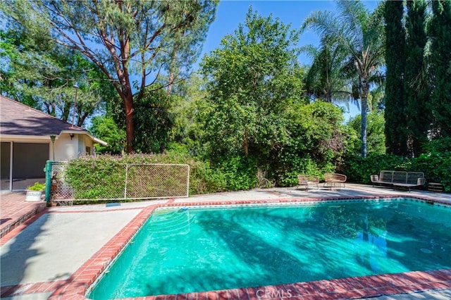 outdoor pool featuring a patio area and fence