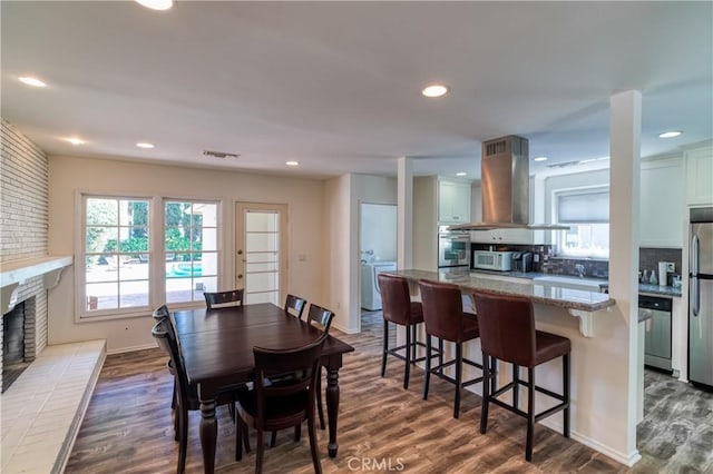 dining area featuring a fireplace, recessed lighting, visible vents, dark wood-type flooring, and baseboards