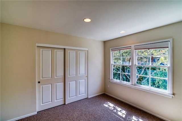 unfurnished bedroom featuring carpet floors, recessed lighting, a closet, and baseboards