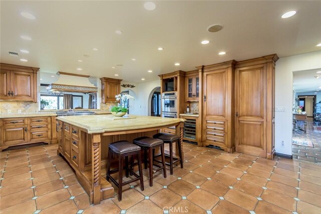 420 Inverness Dr, La Canada Flintridge, CA 91011 - kitchen featuring brown cabinetry, a kitchen island, light countertops, custom range hood, and recessed lighting