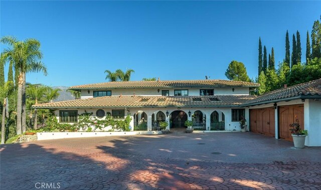 420 Inverness Dr, La Canada Flintridge, CA 91011 - mediterranean / spanish house with curved driveway, stucco siding, and a tiled roof