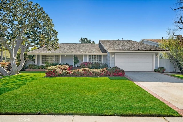 ranch-style home with concrete driveway, a garage, and a front yard