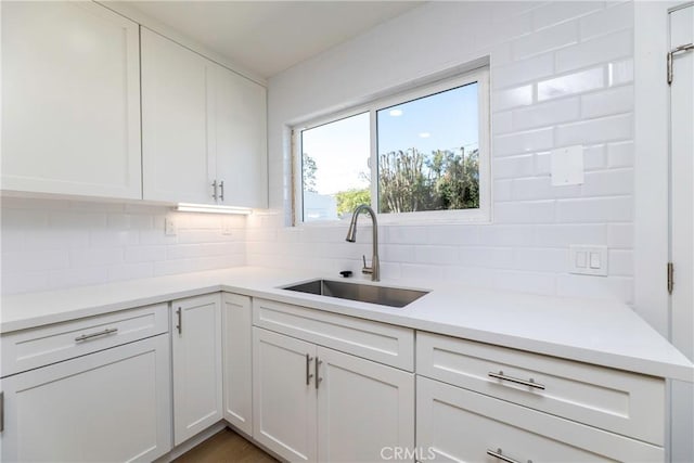 kitchen with white cabinetry, a sink, and decorative backsplash