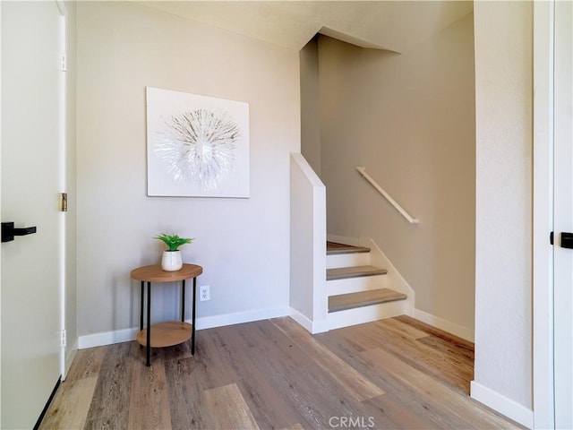 stairway featuring wood finished floors and baseboards