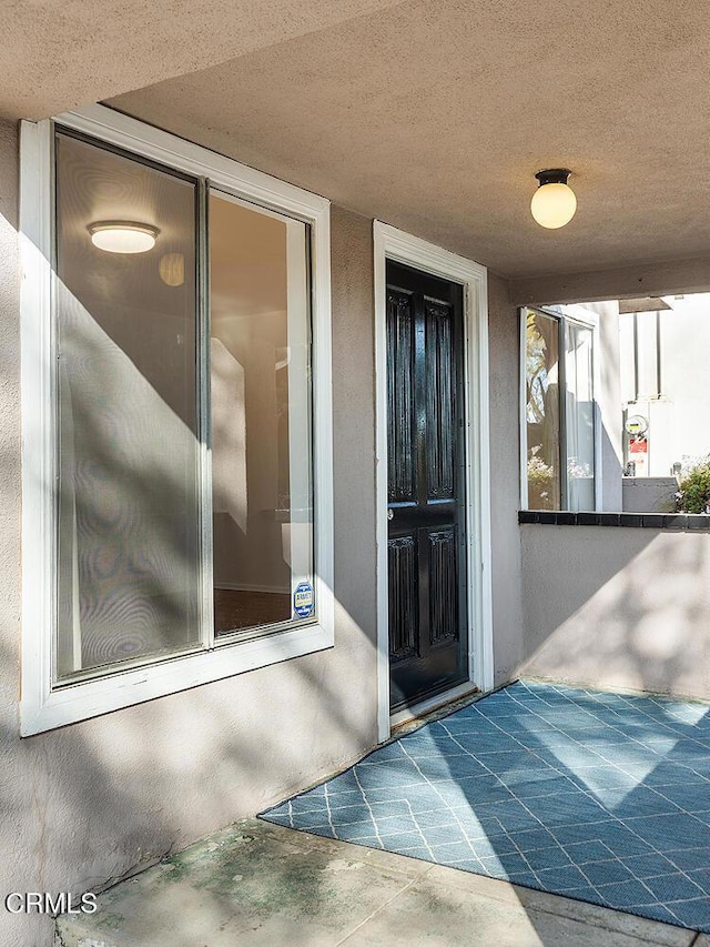 doorway to property with stucco siding