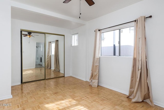 unfurnished room with ceiling fan and baseboards