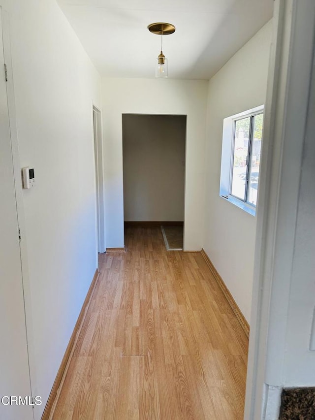 hallway with baseboards and light wood-style floors