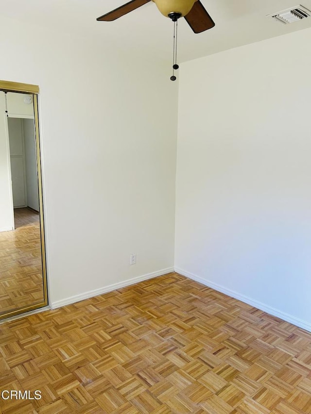 unfurnished room featuring baseboards, visible vents, and a ceiling fan