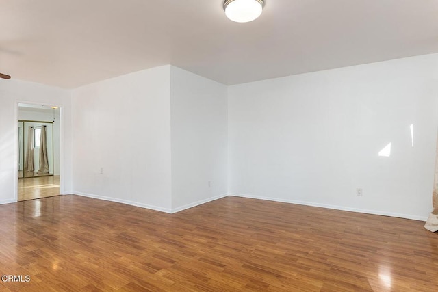 empty room with baseboards and wood finished floors