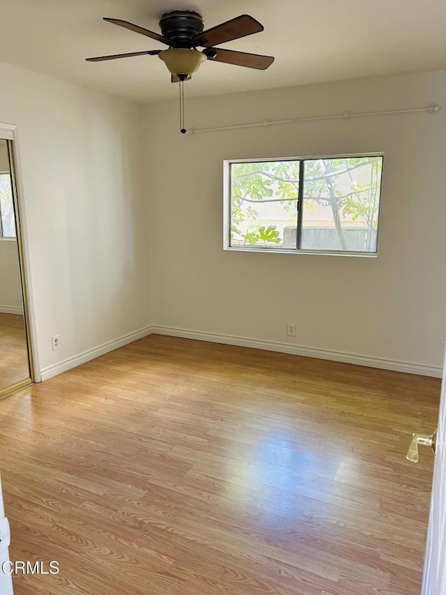 unfurnished room featuring light wood-style flooring, baseboards, and ceiling fan