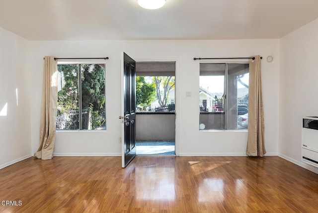 doorway to outside featuring plenty of natural light, baseboards, and wood finished floors