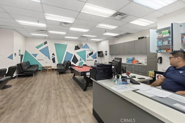 office featuring light wood-style floors, visible vents, and a drop ceiling