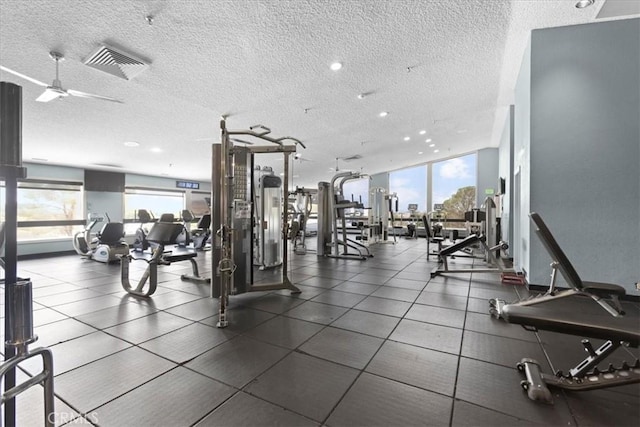 gym featuring a textured ceiling, visible vents, ceiling fan, and a wealth of natural light