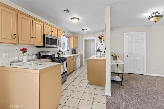 kitchen featuring light tile patterned floors, appliances with stainless steel finishes, visible vents, light brown cabinets, and light countertops