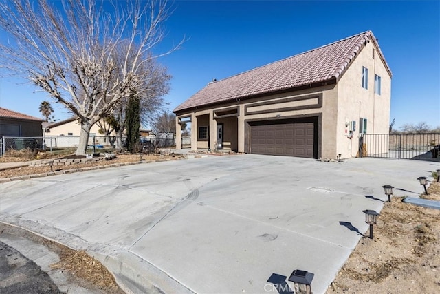 view of front of home with driveway, fence, and stucco siding