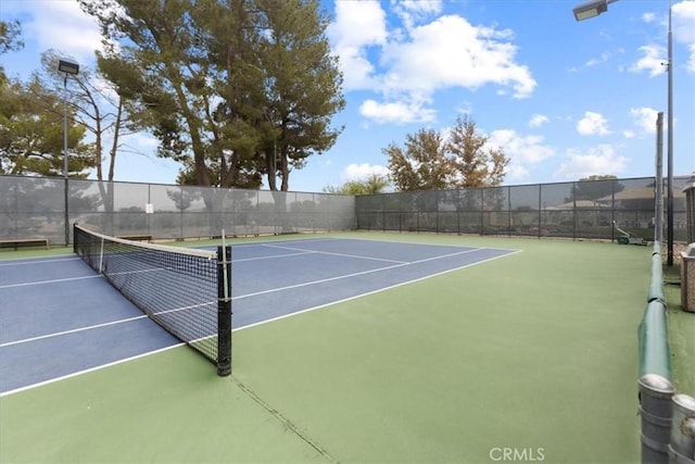 view of tennis court featuring fence and community basketball court