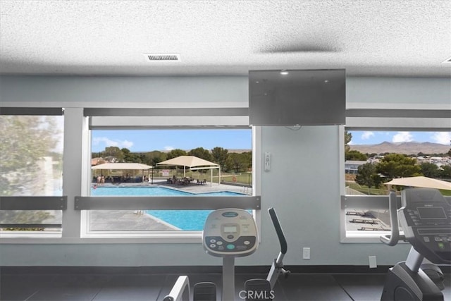 details with a textured ceiling, visible vents, and baseboards