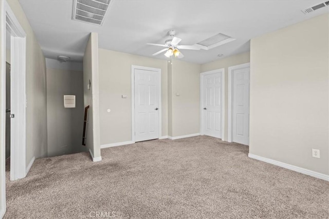 unfurnished bedroom with visible vents, attic access, and carpet flooring