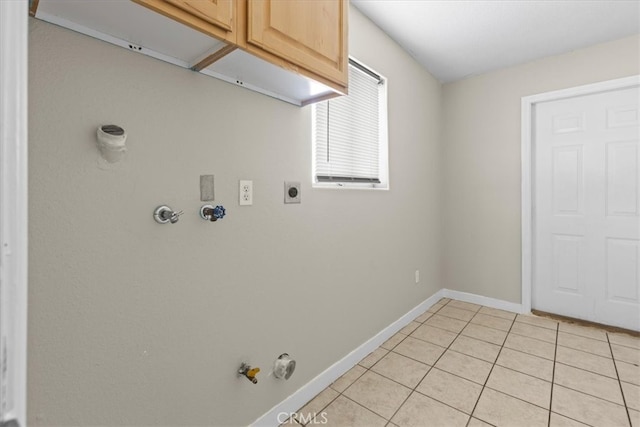 clothes washing area featuring cabinet space, hookup for a gas dryer, light tile patterned flooring, electric dryer hookup, and baseboards