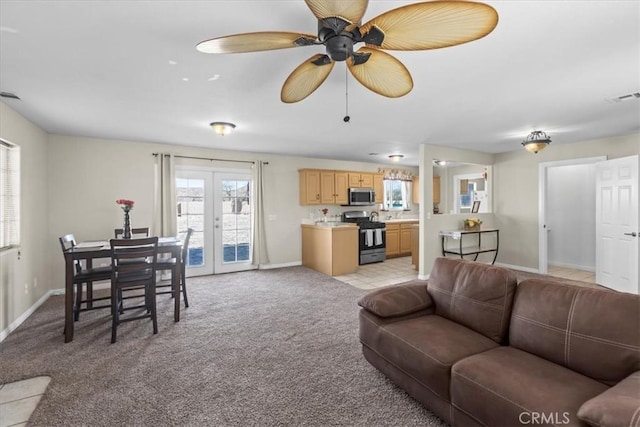 living area with visible vents, baseboards, light carpet, french doors, and a ceiling fan
