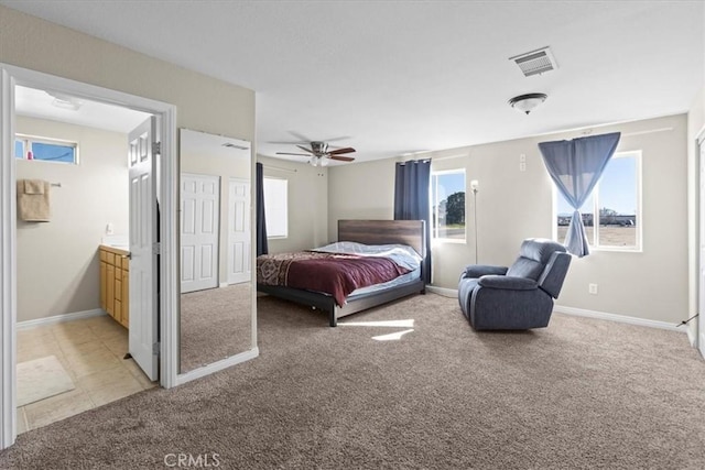 bedroom with multiple windows, light colored carpet, and visible vents