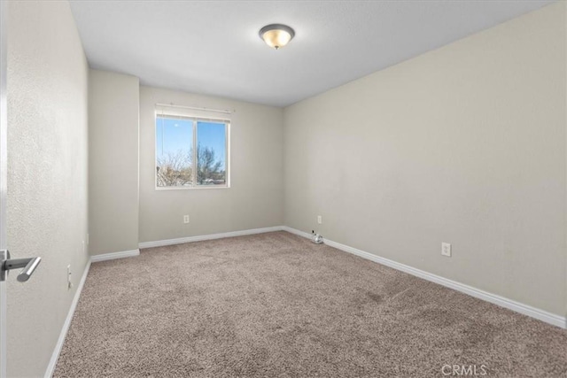 unfurnished room featuring carpet flooring and baseboards