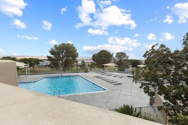 pool with a patio and fence