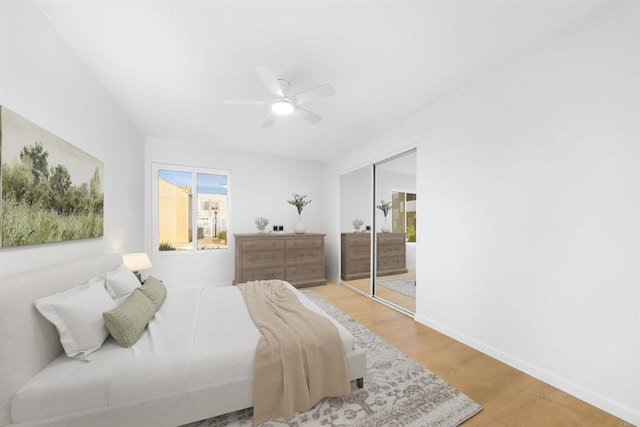 bedroom featuring baseboards, wood finished floors, a closet, and ceiling fan