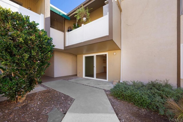 entrance to property featuring a balcony and a patio