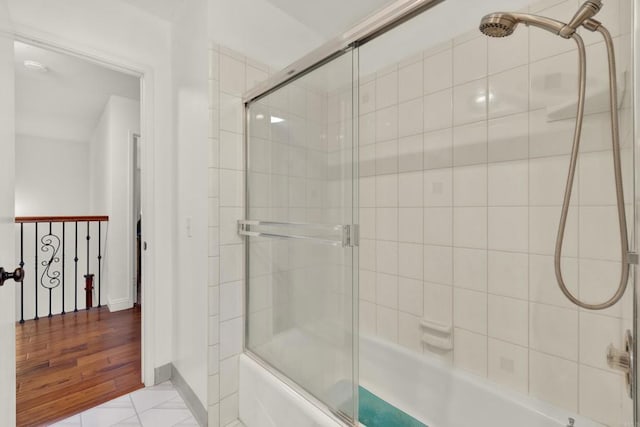 full bath with baseboards, combined bath / shower with glass door, and tile patterned floors