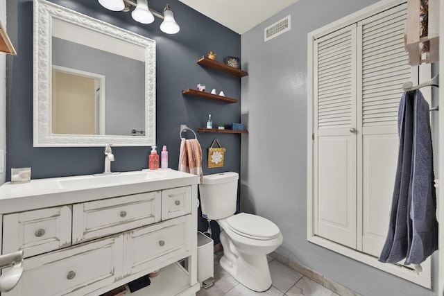 bathroom featuring toilet, vanity, and visible vents