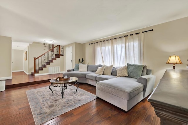 living room featuring baseboards, stairs, visible vents, and hardwood / wood-style floors