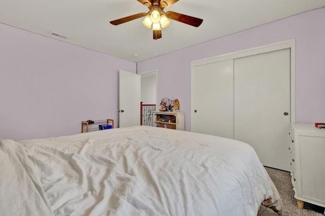 bedroom with carpet, visible vents, ceiling fan, and a closet