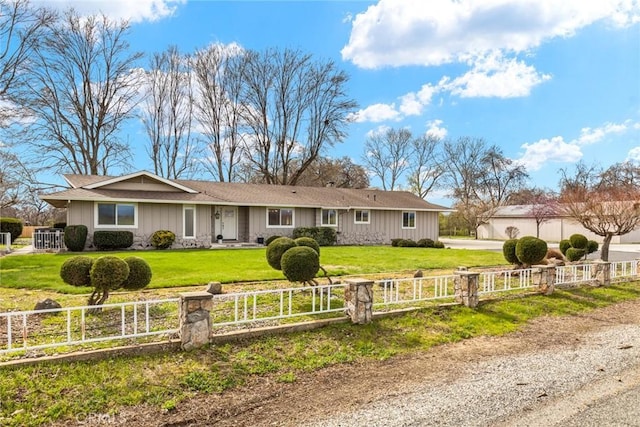 ranch-style house with a fenced front yard and a front lawn