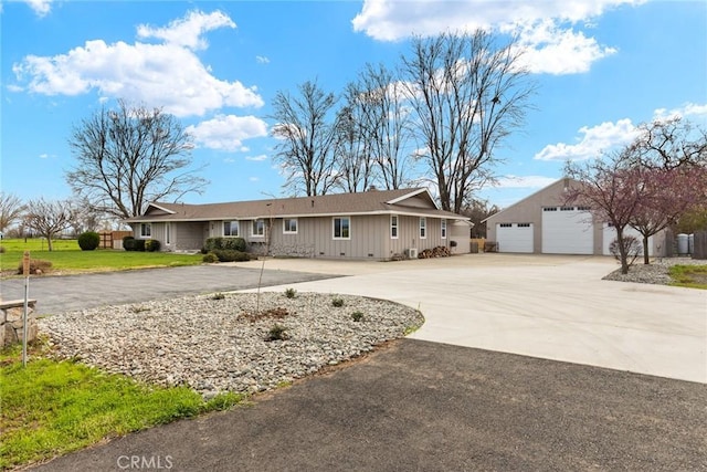 single story home featuring a garage, a front lawn, and an outdoor structure