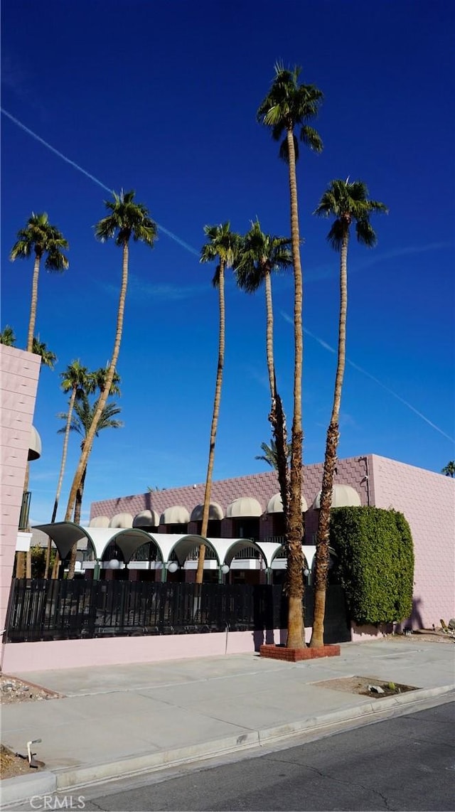 view of building exterior featuring fence and driveway