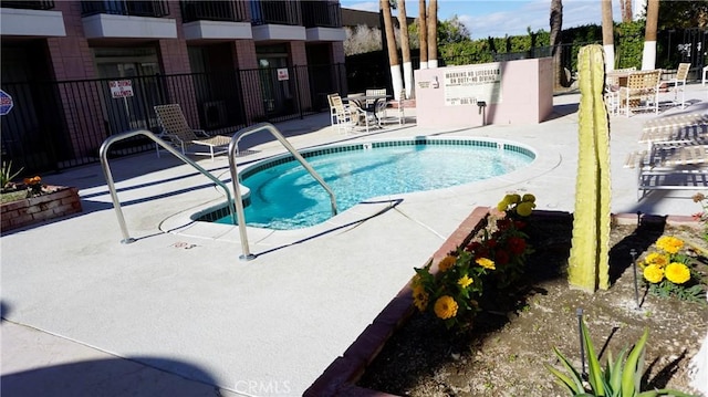 view of pool featuring a patio and fence