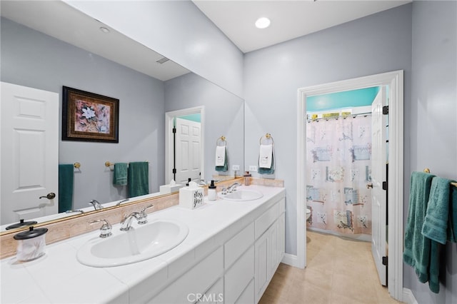 bathroom featuring a shower with shower curtain, a sink, toilet, and double vanity