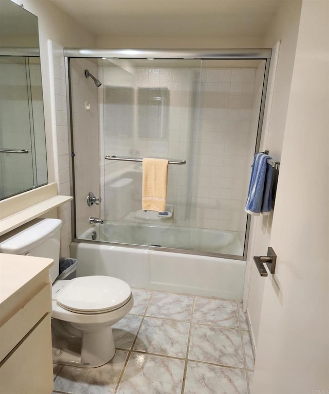 bathroom with enclosed tub / shower combo, vanity, and toilet