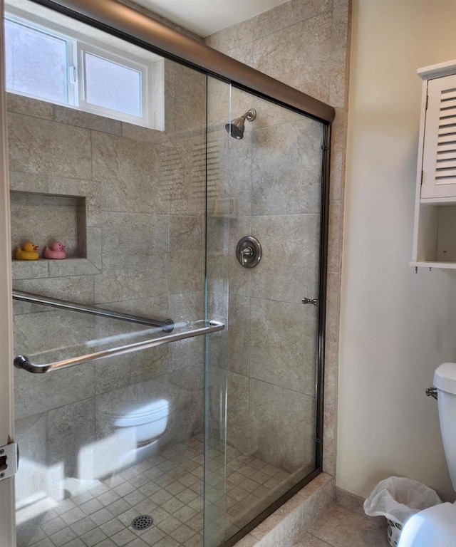 bathroom featuring a shower stall and toilet