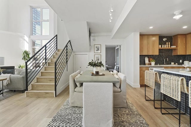 dining space featuring recessed lighting, light wood-style flooring, baseboards, and stairs