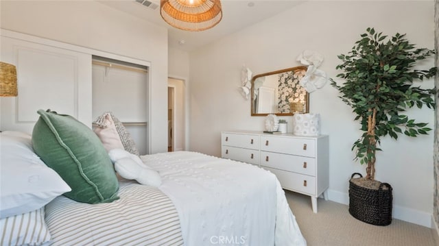 carpeted bedroom with baseboards, visible vents, and a closet