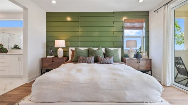 bedroom featuring baseboards, recessed lighting, ensuite bathroom, and access to exterior