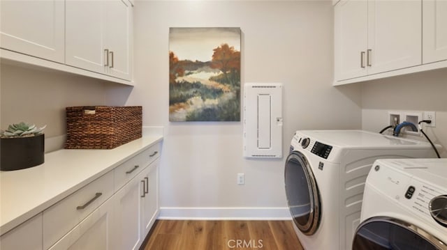 laundry room featuring independent washer and dryer, wood finished floors, cabinet space, and baseboards