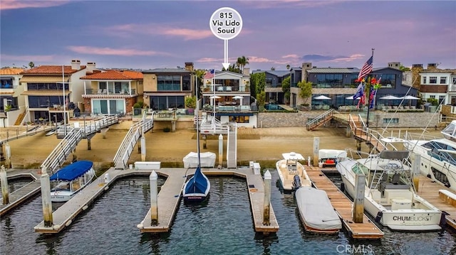 view of dock with a water view and a residential view