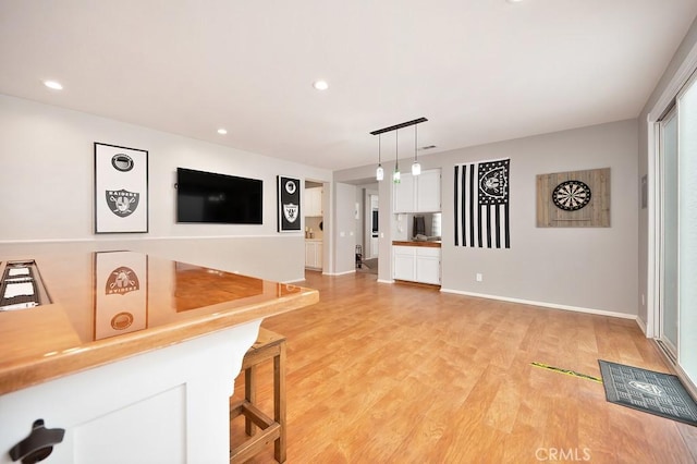 living room with light wood-style floors, recessed lighting, and baseboards