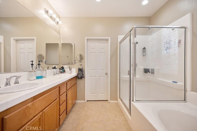 full bath featuring a stall shower, double vanity, a sink, and tile patterned floors