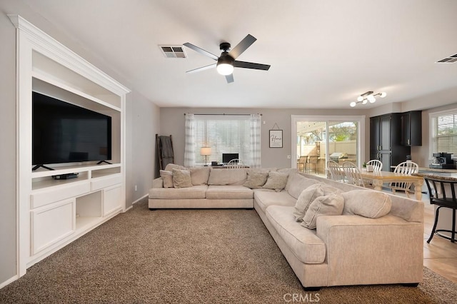 living room with carpet floors, visible vents, and ceiling fan